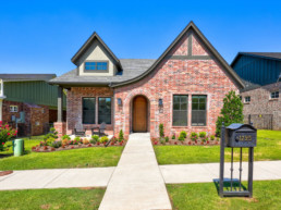 real estate photo showing a brick house with a mailbox in the front yard