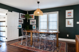 a dining room with a wood table and clear modern chairs