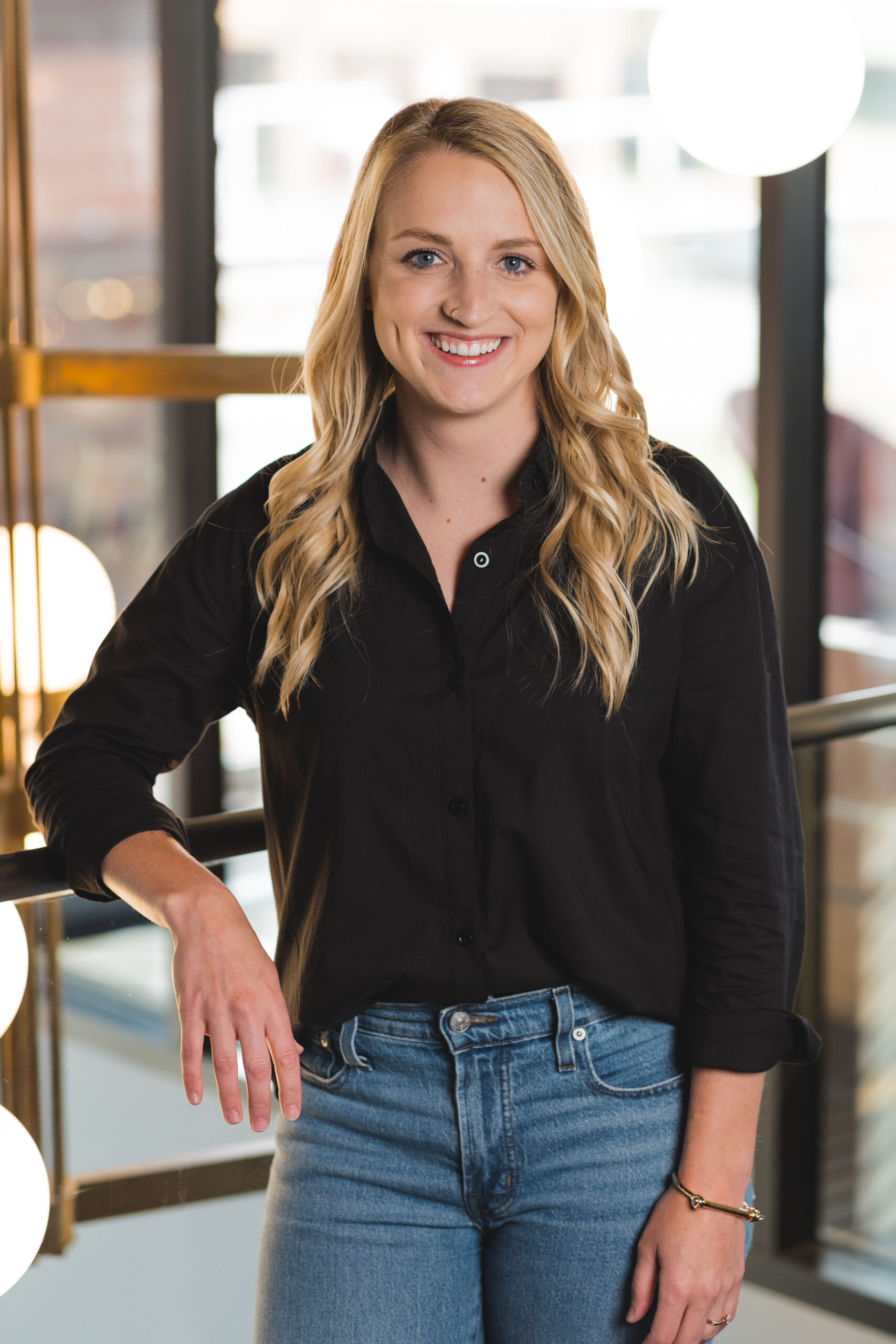 a woman standing in front of a window smiling