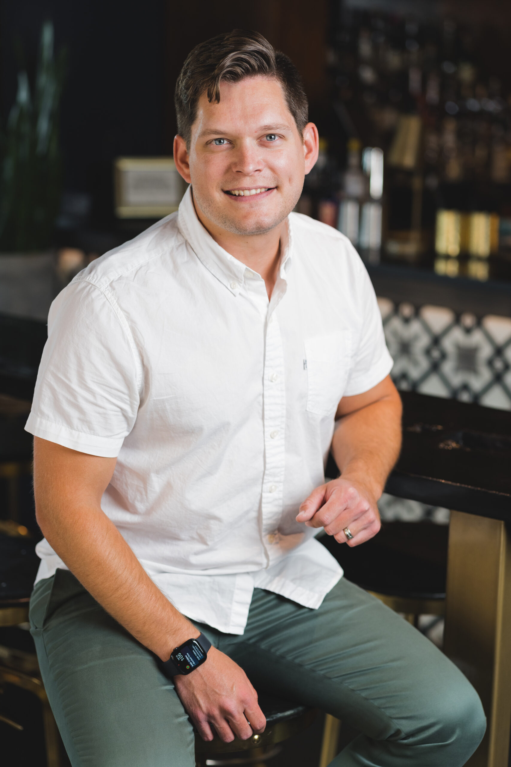 a man sitting at a bar wearing green pants