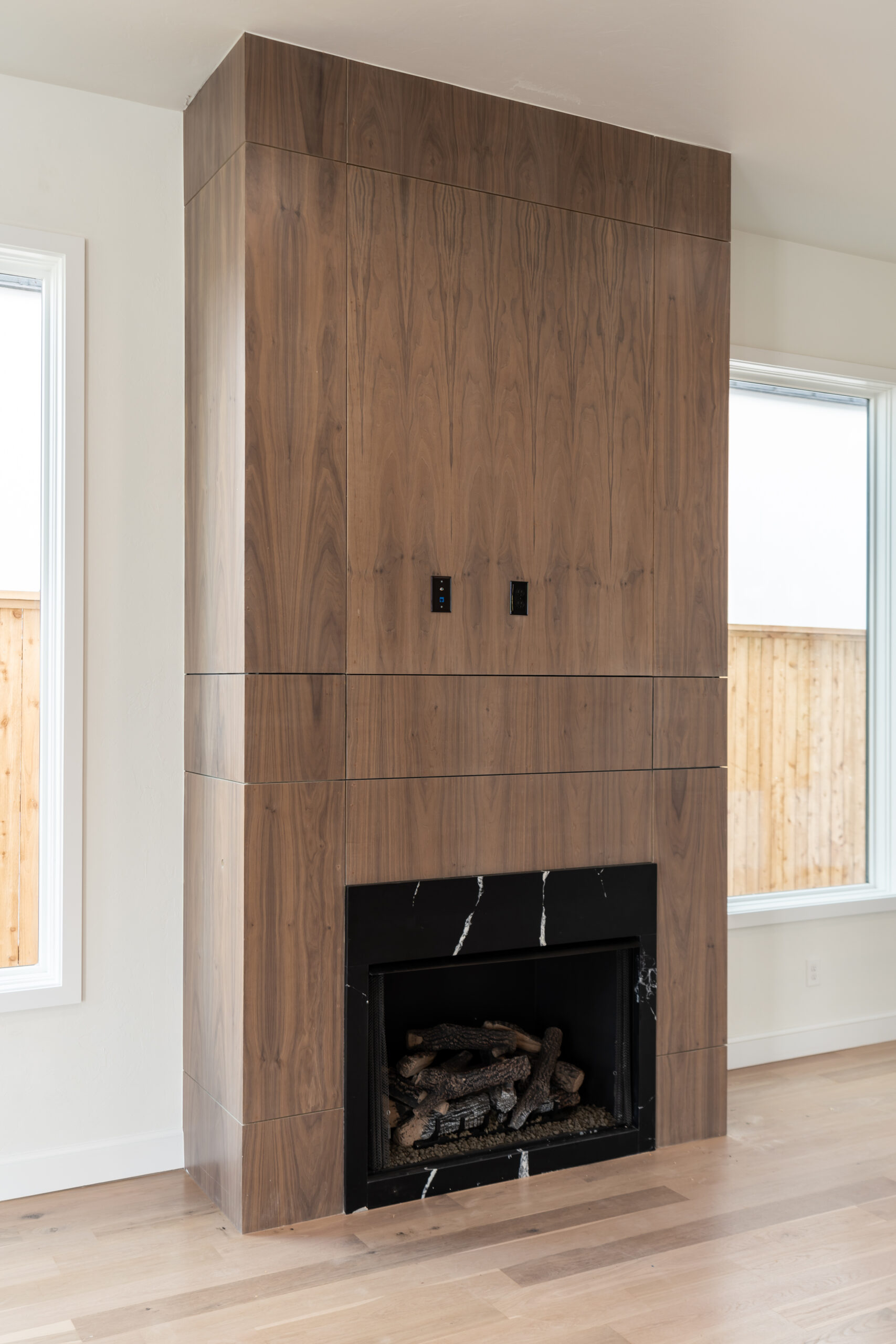 a fireplace in a living room with wood paneling